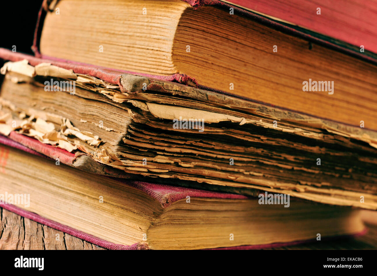 closeup of a pile of worn-out old books on a rustic wooden table Stock