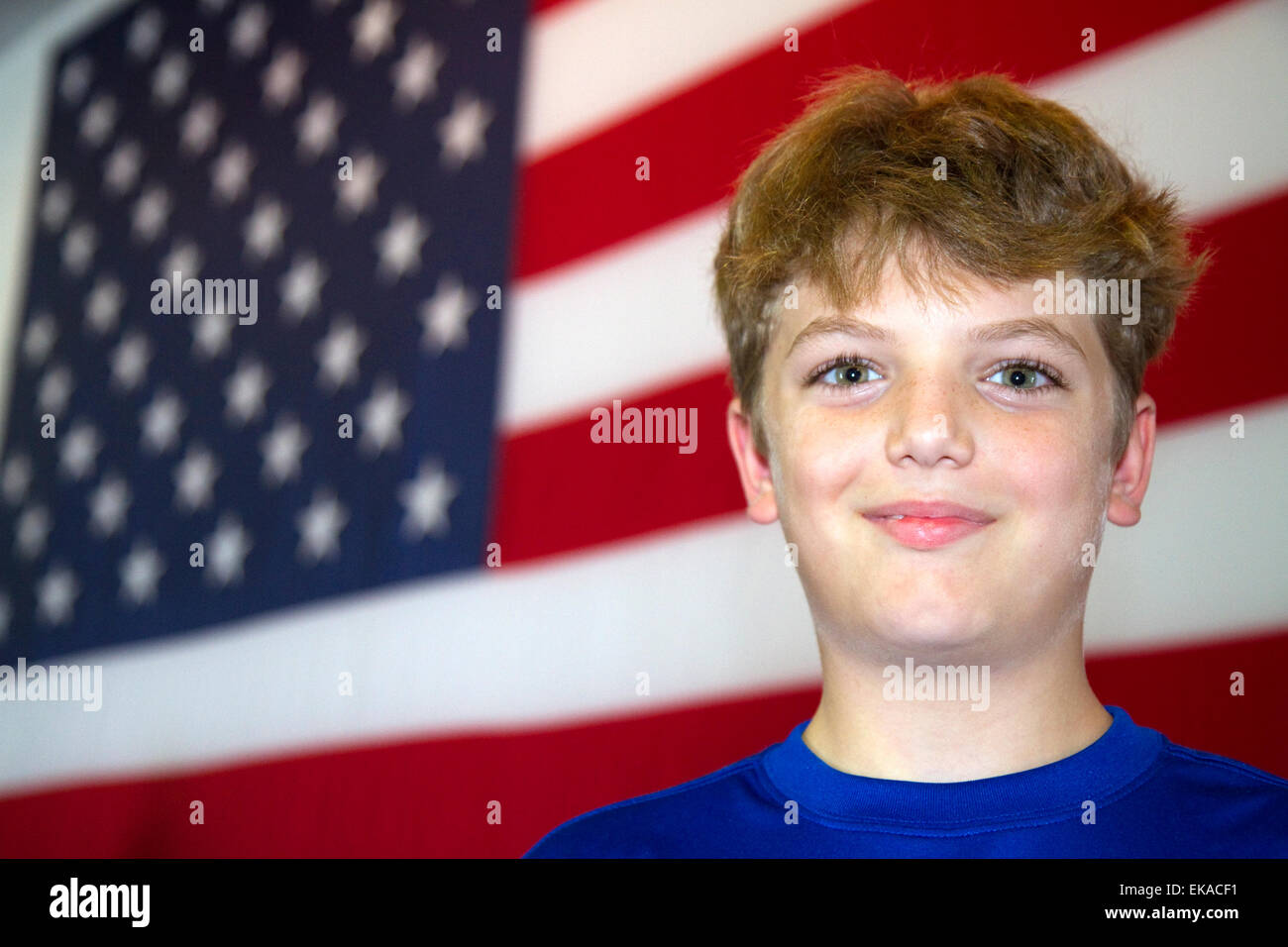 Ten year old american boy standing in front of an american flag in Charleston, South Carolina, USA. MR Stock Photo