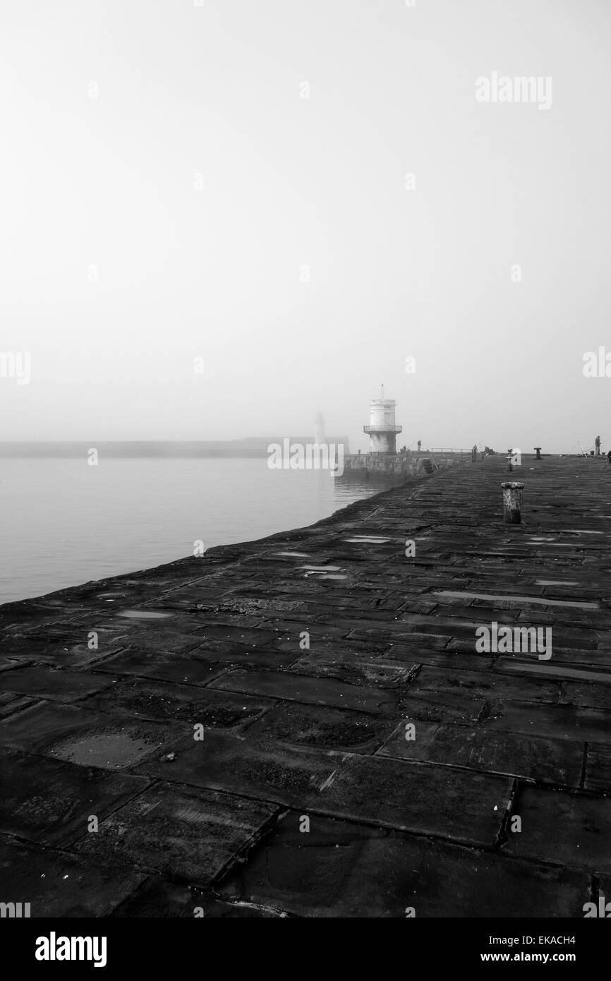 the historic whitehaven harbour and marina on a misty day in black and white Stock Photo