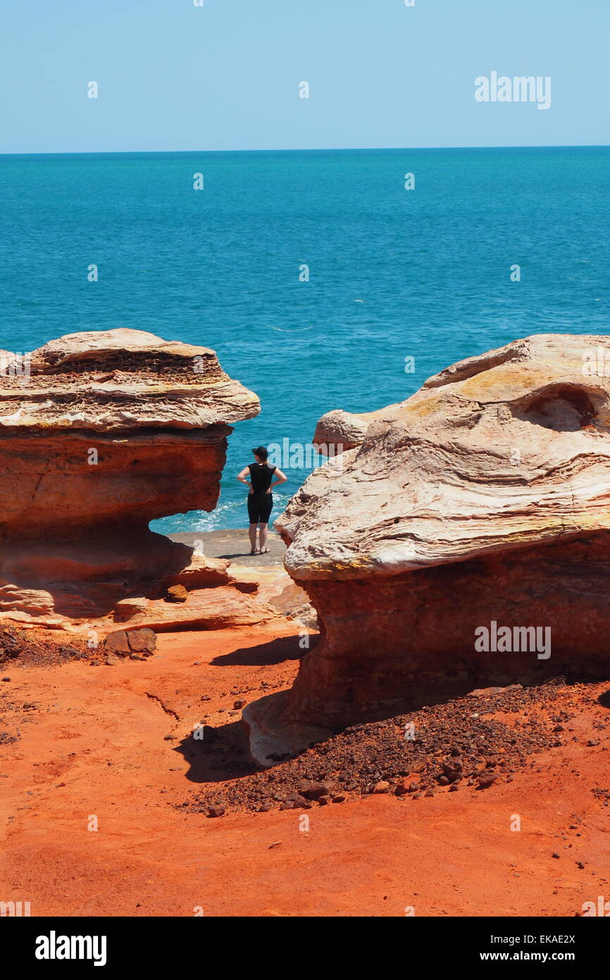 Woman standing on pindan red rocks at Gantheaume Point Broome, Western Australia. Stock Photo
