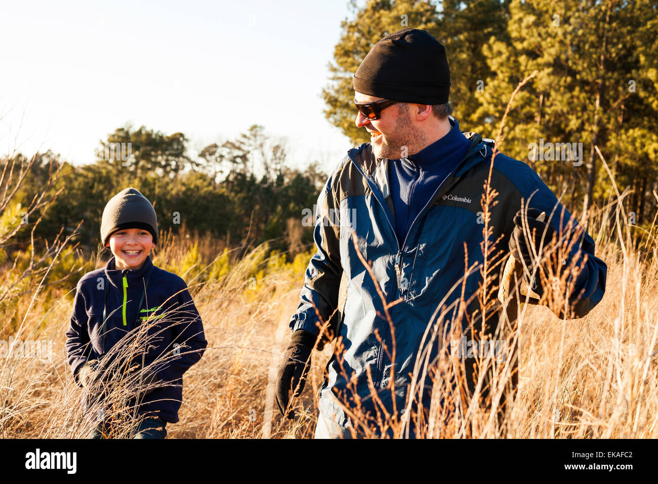 Father and son hiking in field Stock Photo