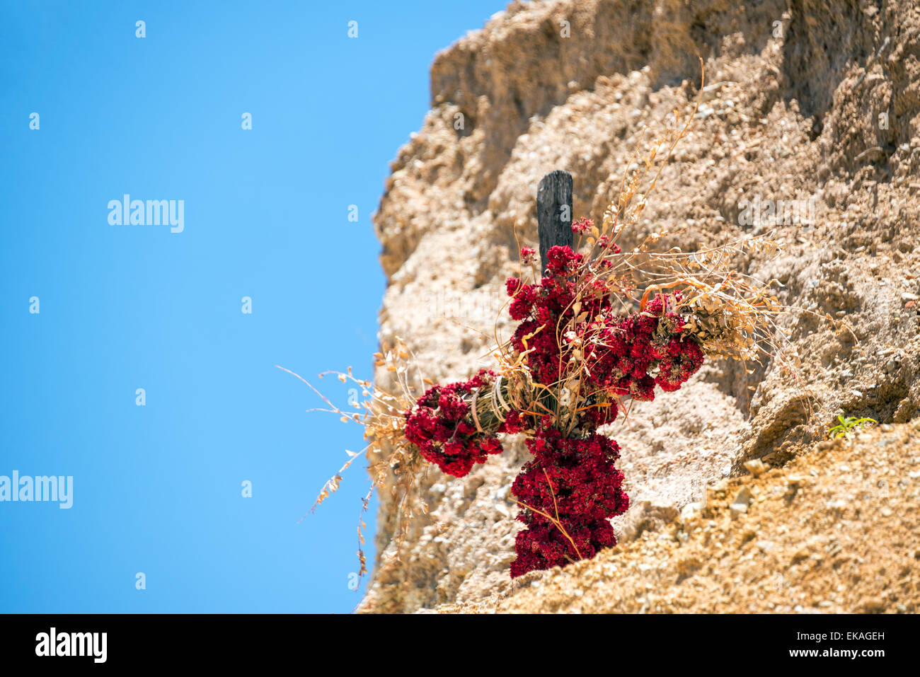 Cross covered in flowers inside of Colca Canyon in Peru Stock Photo