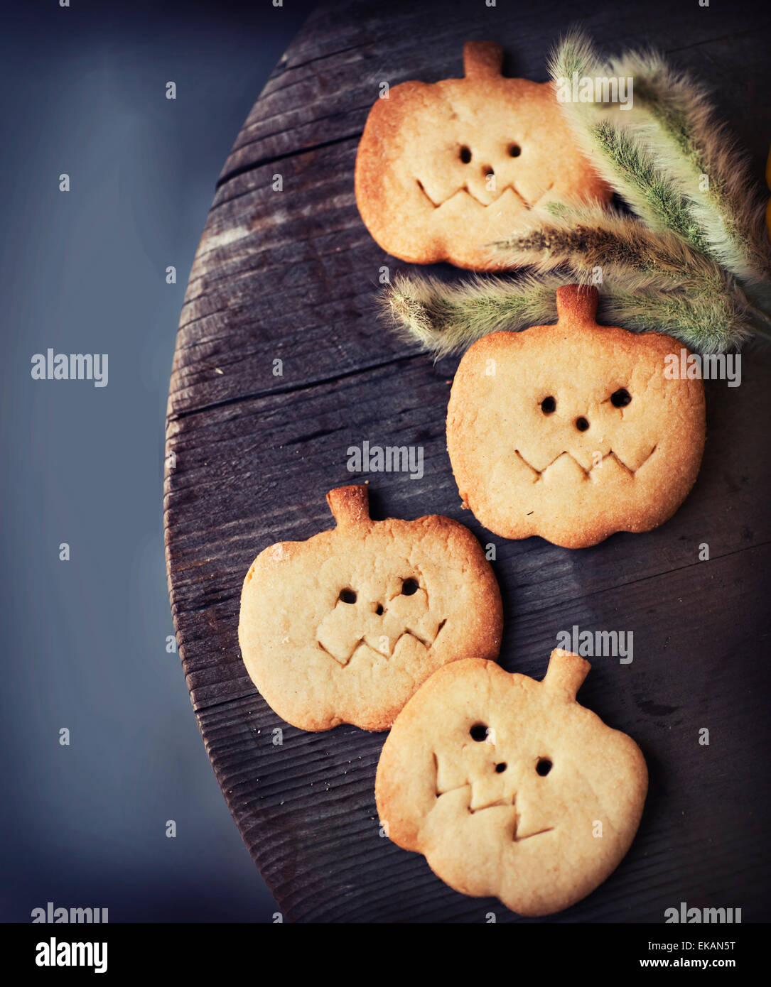 Halloween homemade gingerbread cookie in pumpkin shape over wooden background Stock Photo