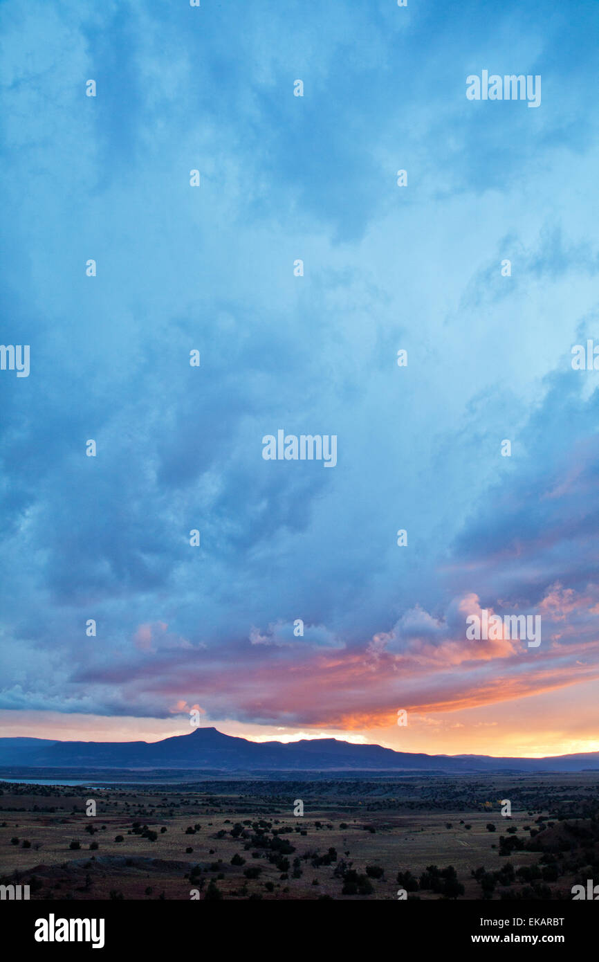 A moody sky dominates the landscape over the iconic peak of Pedernal in northern New Mexico at the resort of Ghost Ranch. Stock Photo