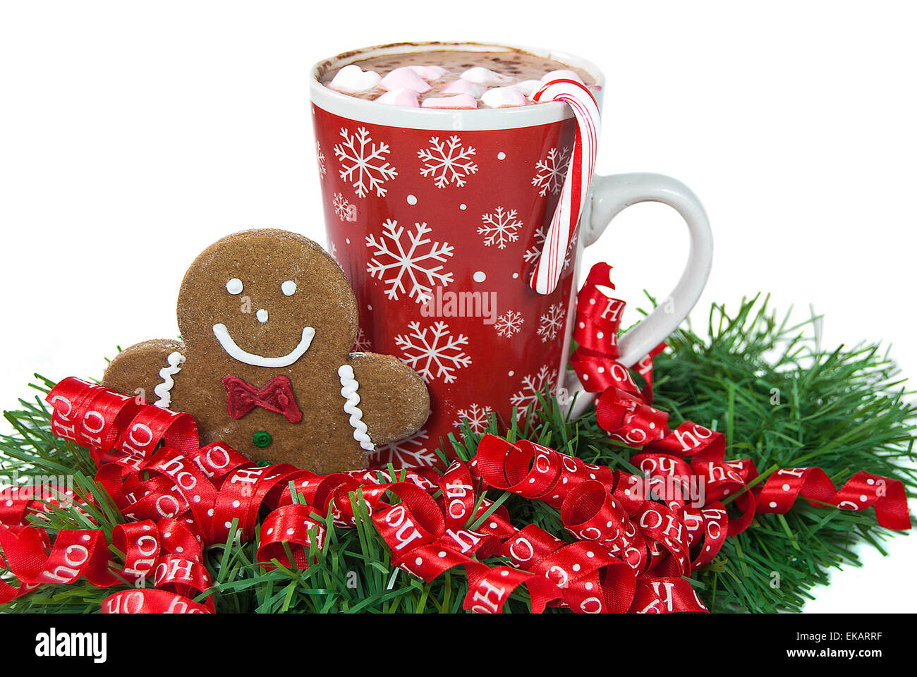 Christmas gingerbread man in ribbons with hot chocolate isolated on white. Stock Photo