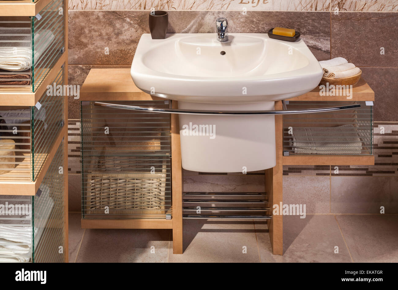 detail of a modern bathroom with sink and cupboard for towels Stock Photo