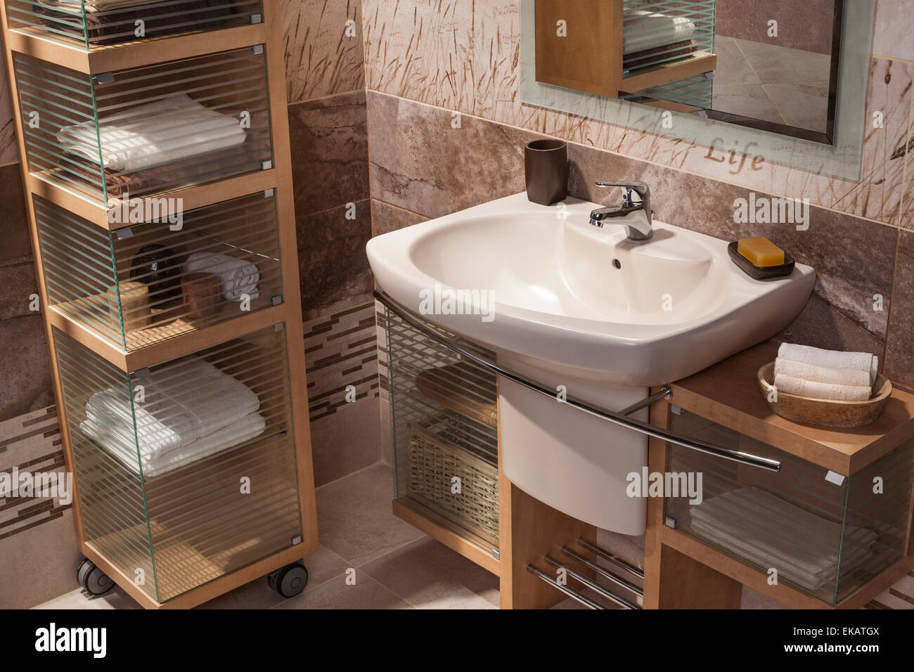 detail of a modern bathroom with sink and cupboard for towels Stock Photo