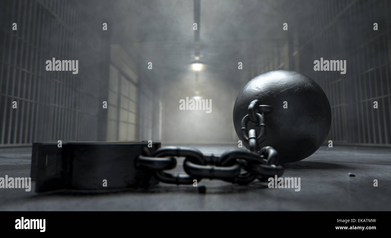 A vintage ball and chain with an open shackle on an old prison cell