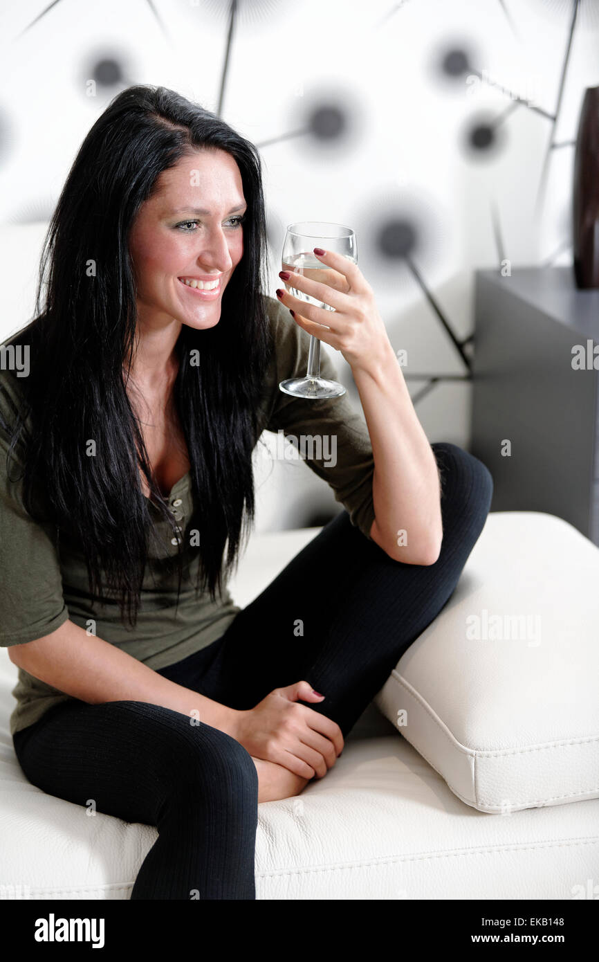 Woman relaxing on her sofa with a drink Stock Photo - Alamy