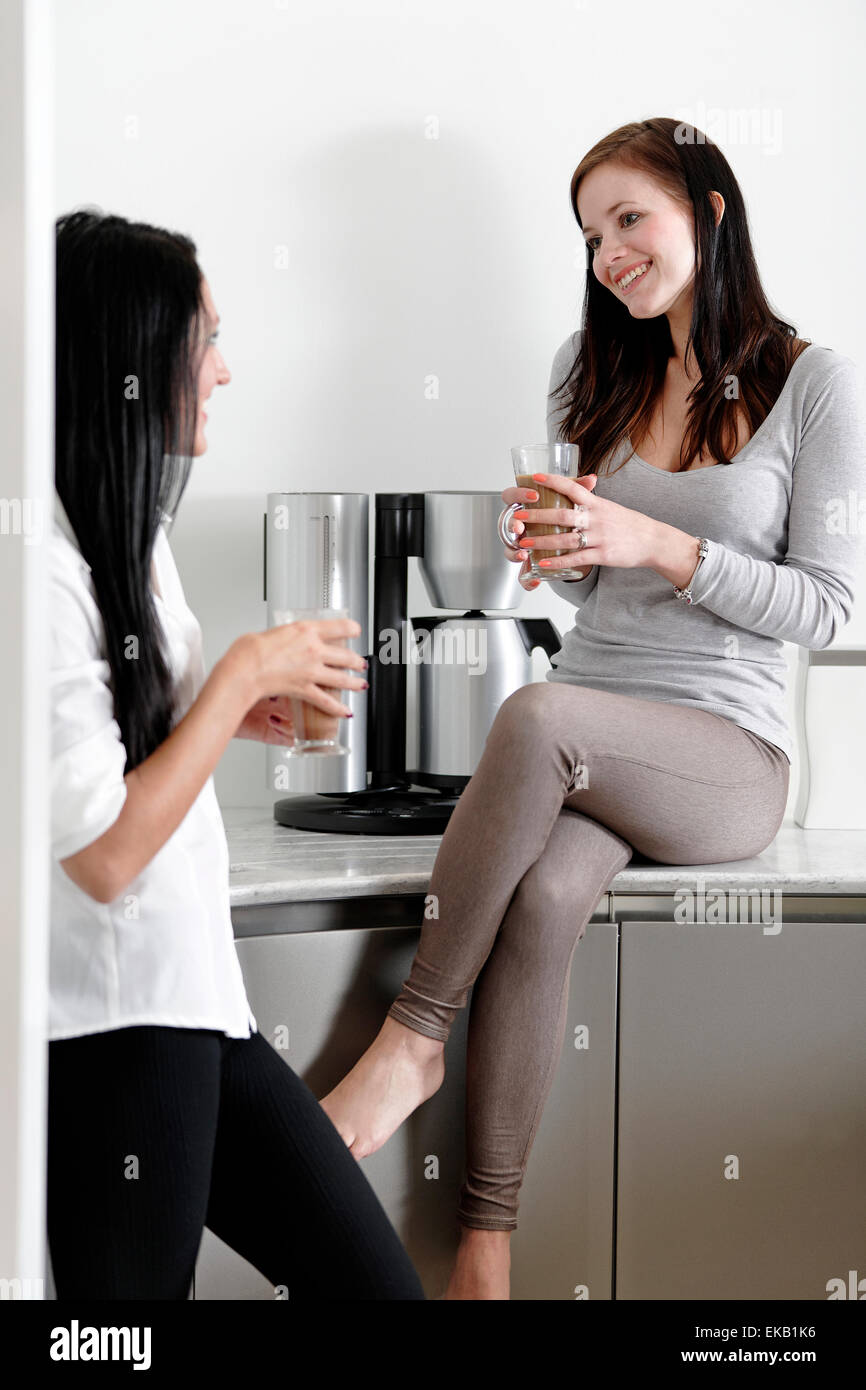 Two friends catching up in the kitchen Stock Photo - Alamy