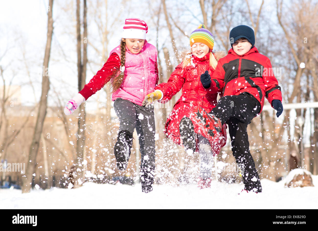 Boy and girls playing with snow in winter park Stock Photo - Alamy