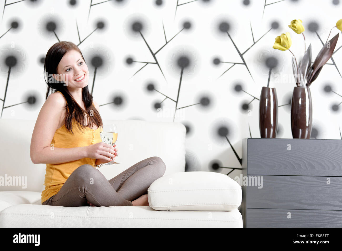 Woman relaxing on her sofa with a drink Stock Photo - Alamy