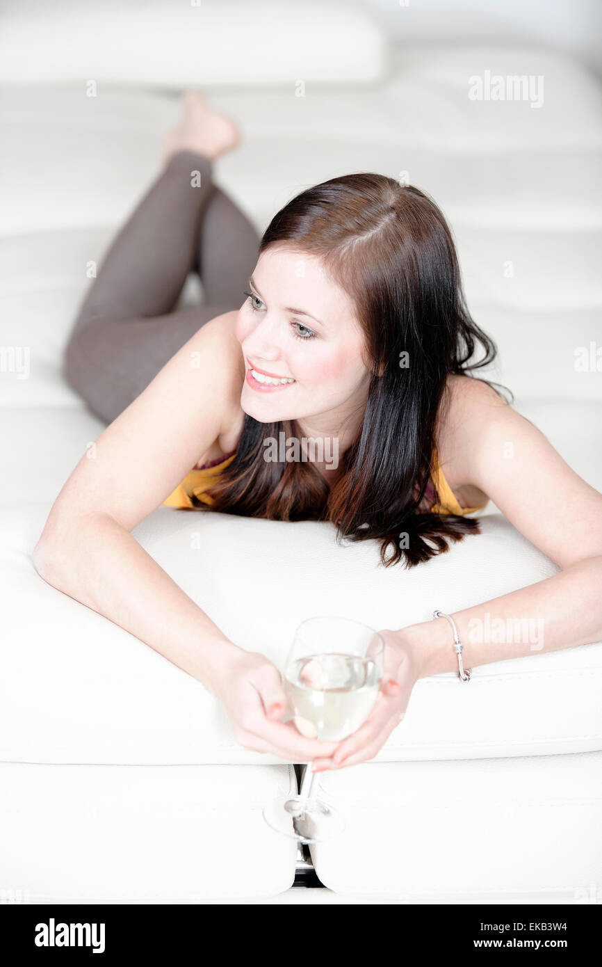 Woman relaxing on her sofa with a drink Stock Photo - Alamy