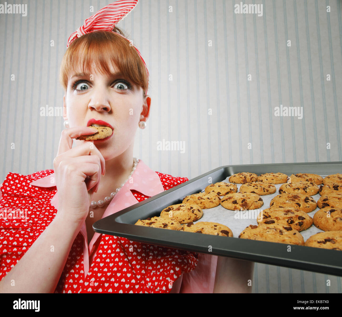 Retro housewife sneaking cookies Stock Photo