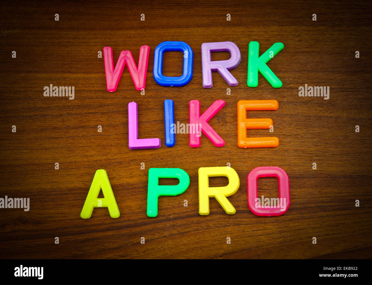 Work like a pro in colorful toy letters on wood background Stock Photo