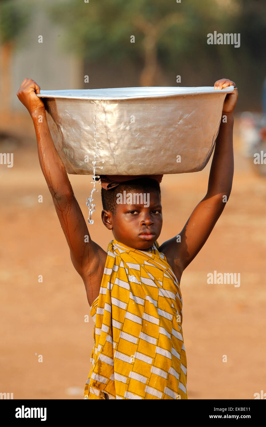 Water chore in an African village, Togo, West Africa, Africa Stock Photo