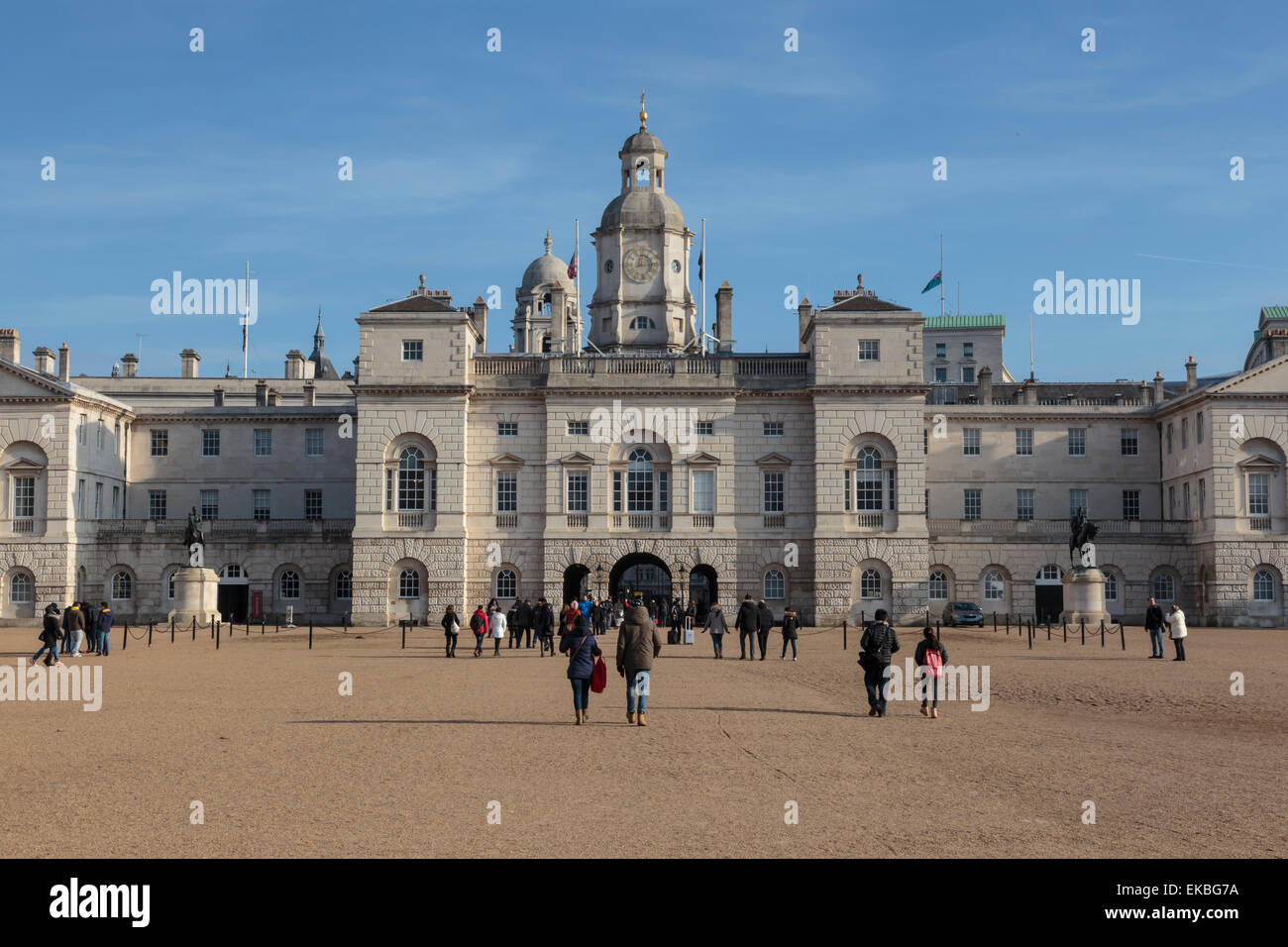 Tourists walk towards the arch of Horse Guards Parade under a winter's blue sky, Whitehall, London, England, United Kingdom Stock Photo