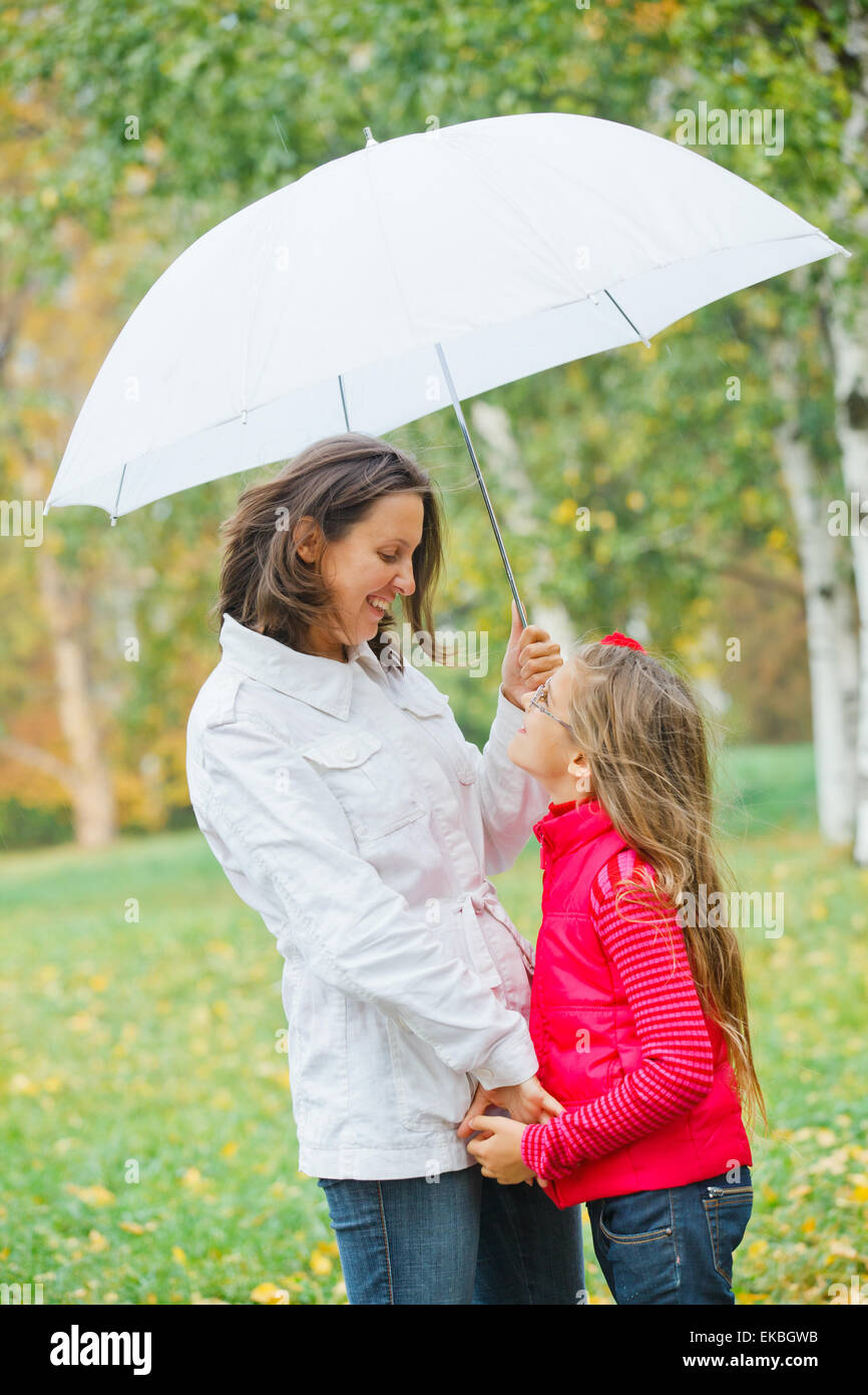 Cute girl with her mother walking in park Stock Photo - Alamy