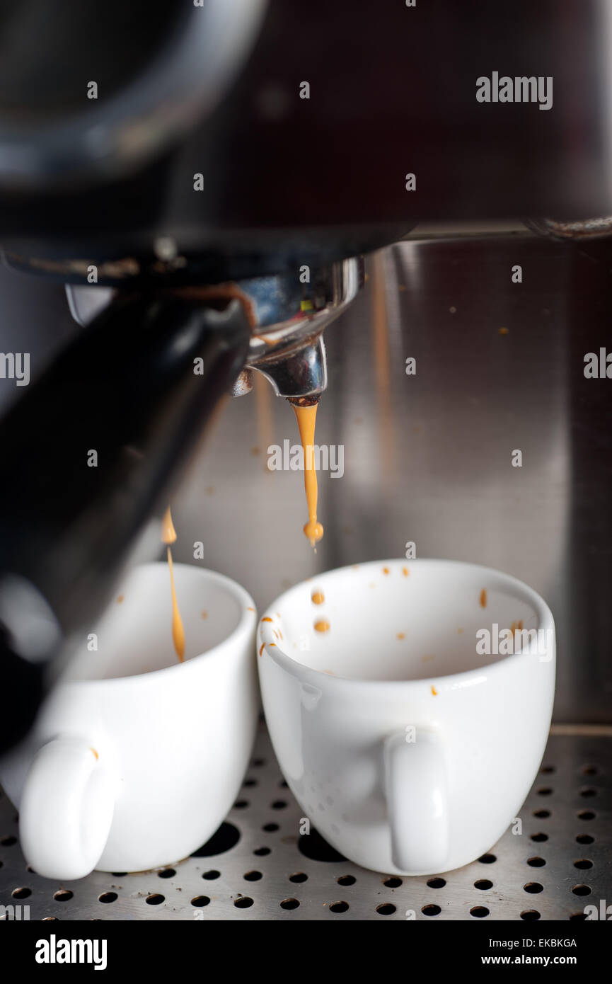 Two espresso cups getting filled in a portafilter machine Stock Photo -  Alamy