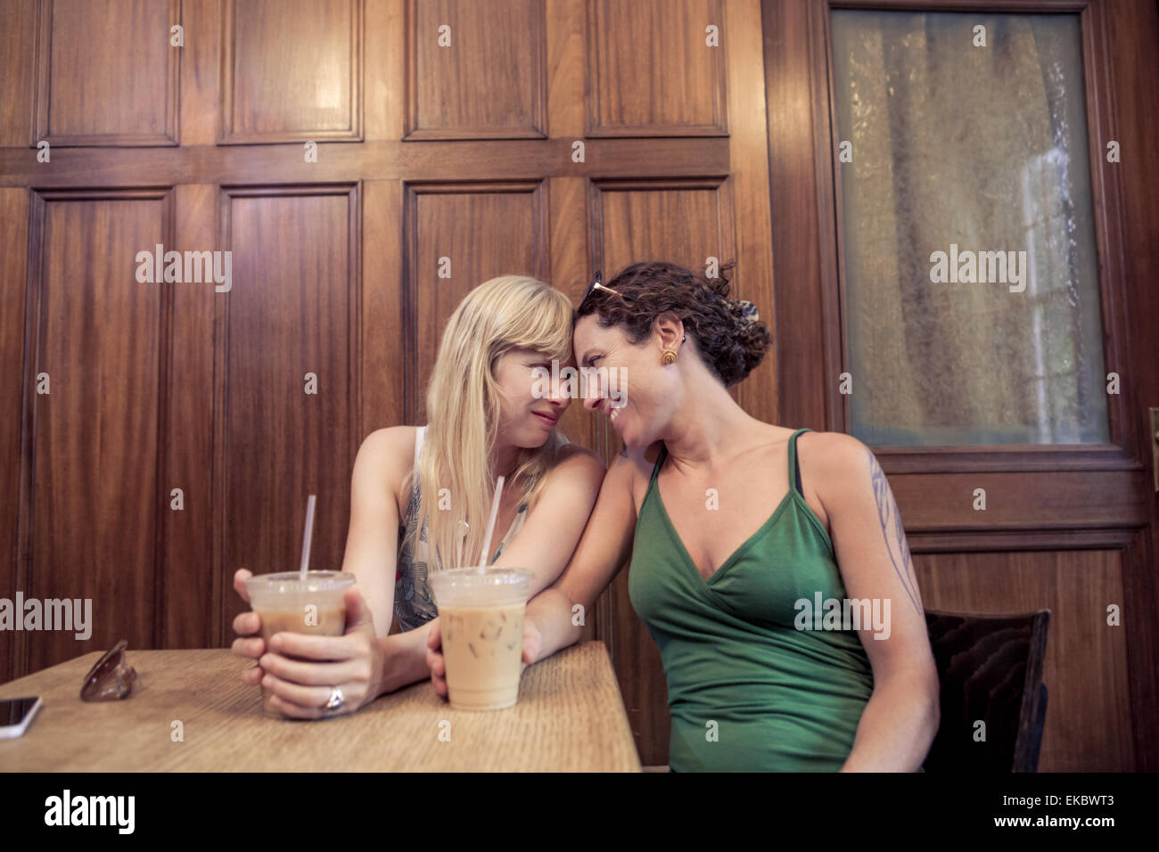 Two women face to face sharing intimacy in cafe Stock Photo