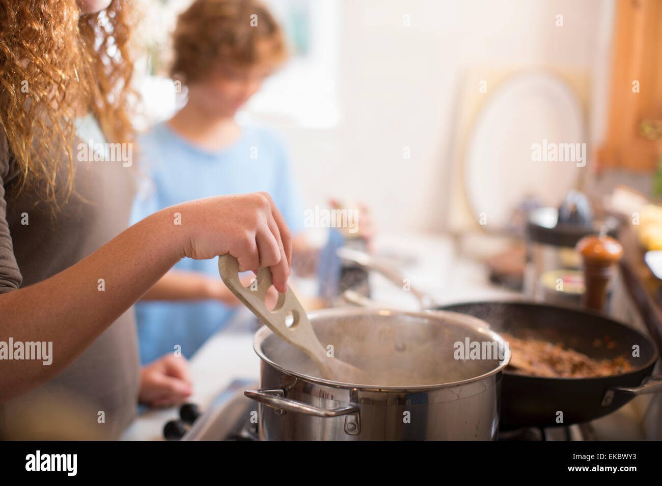 Siblings cooking in kitchen Stock Photo