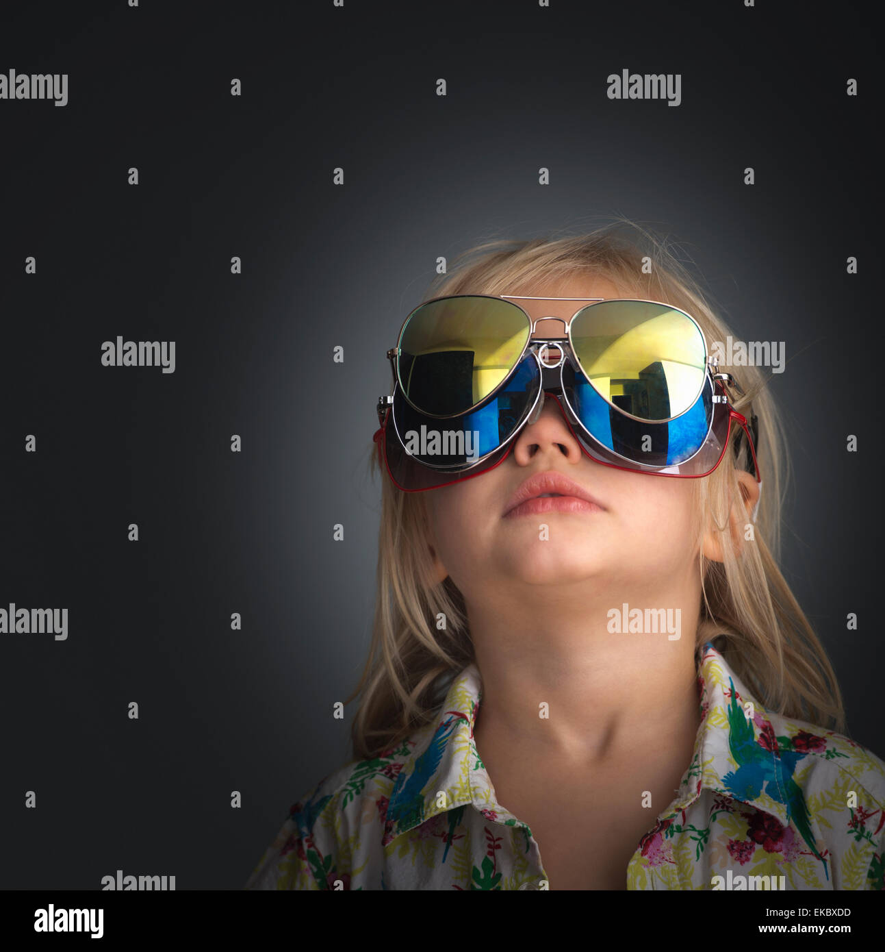 Portrait of young boy wearing 3 pairs of sunglasses Stock Photo
