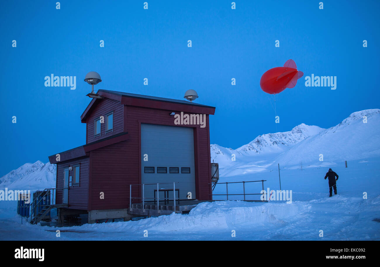 A scientist prepares an airship that will bring up probes of the research base AWIPEV to different heights behind the atmosphere observatory of the resarch station Kings Bay in Ny-Ålesund on Spitsbergen, Norway, 09 April 2015. In the French-German research base AWIPEV scientists of the Alfred-Wegener-Institute (AWI) work together with the French Polar institute Paul Émile Victor (IPEV) in the fields of biological, geological and meteorological research. About 200 million Euros from Germany go to the marine and polar research yearly. 20 million Euros go to resaerch projects related to the Arcti Stock Photo