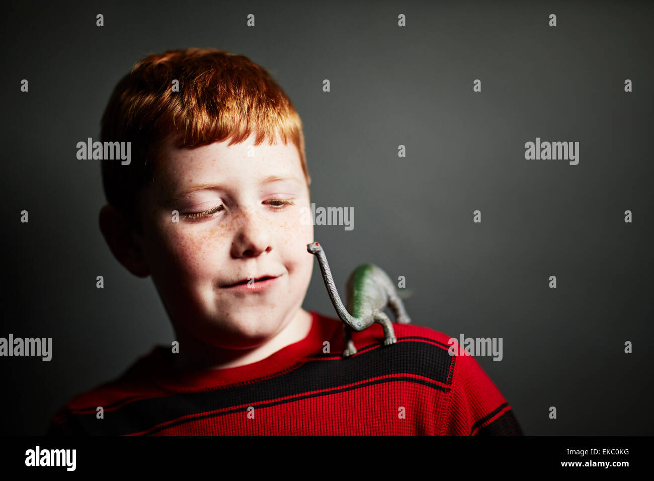 Boy with toy dinosaur on shoulder Stock Photo