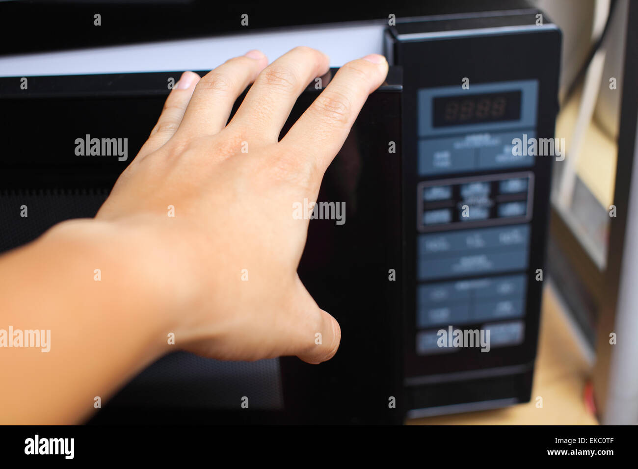 Hand using microwave oven Stock Photo