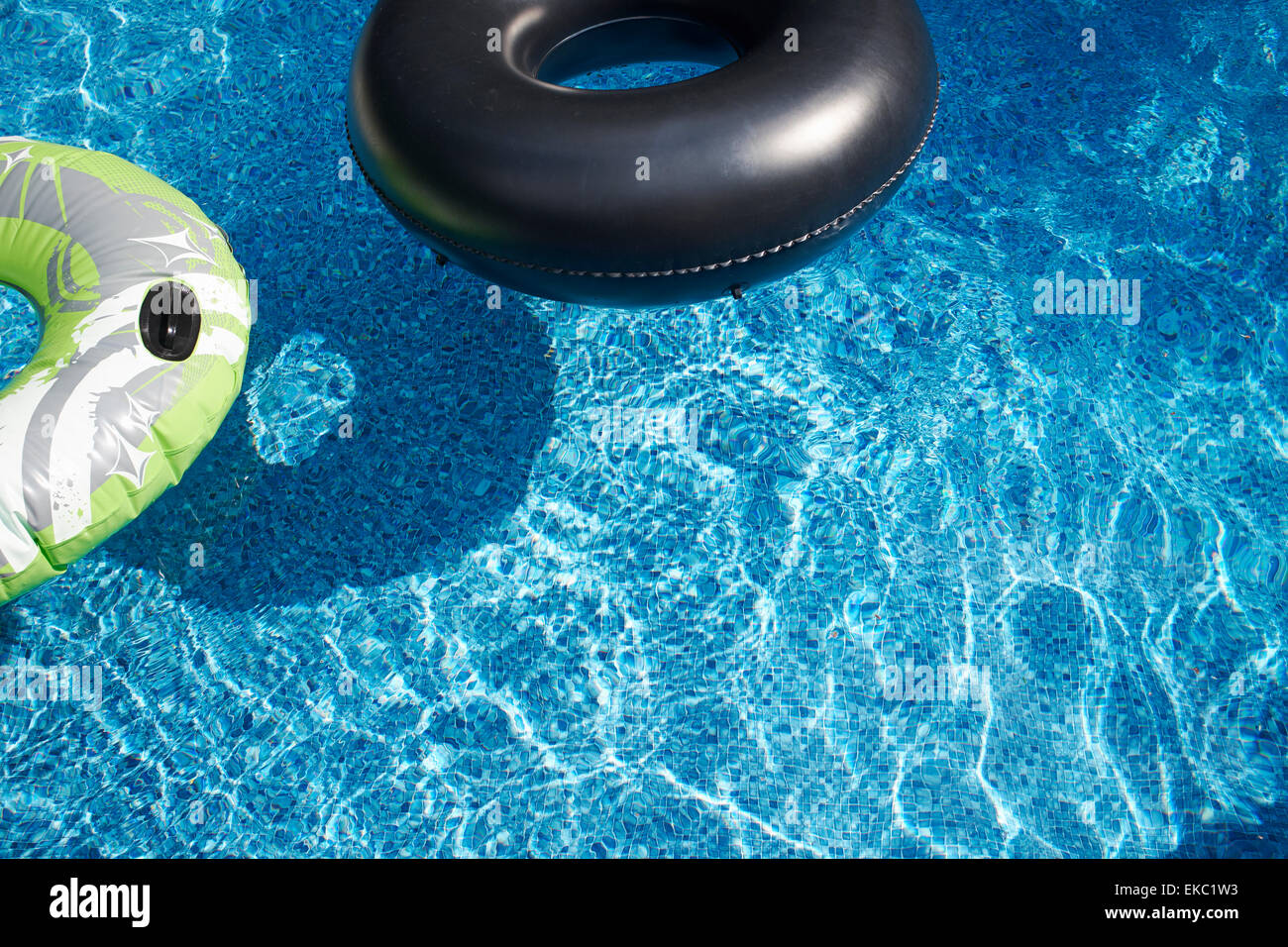 Two rubber rings in sunlit swimming pool Stock Photo