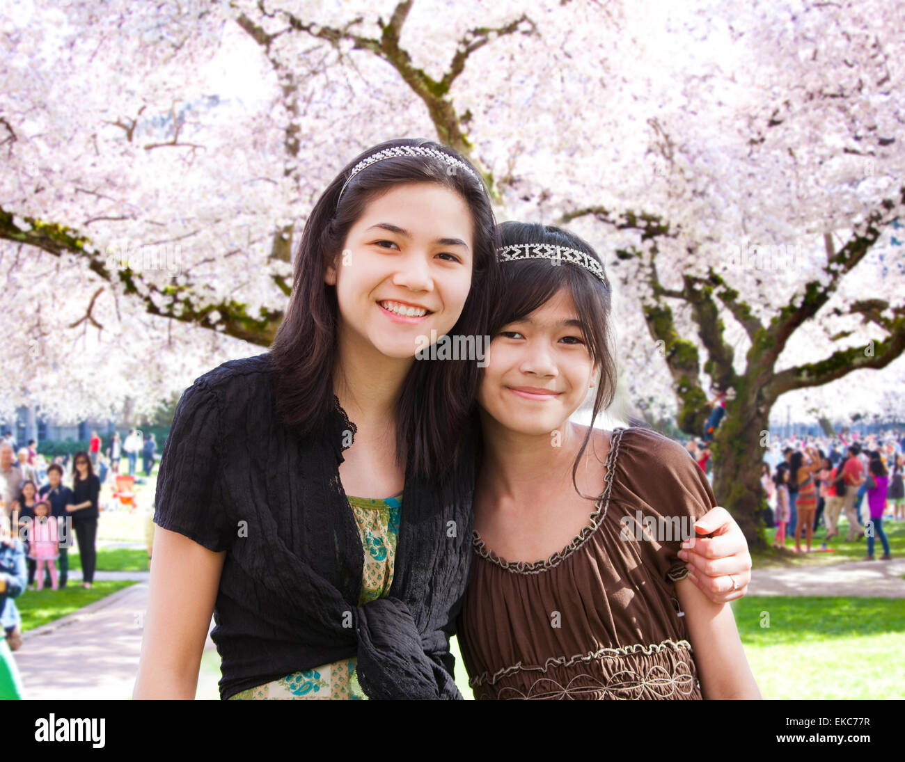 Two girls standing in front of large flowering cherry tree Stock Photo ...