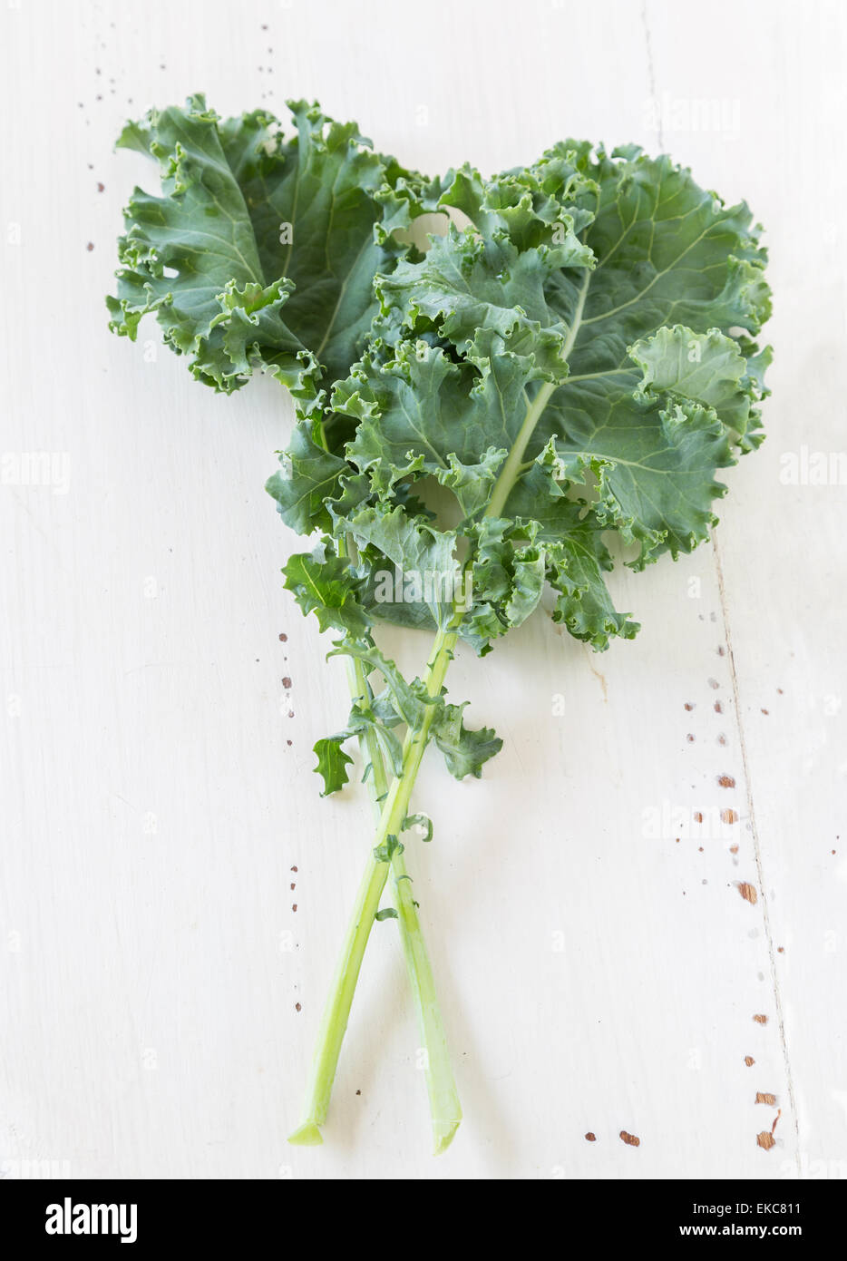 Kale leaves on a cream colored wooden background. Stock Photo