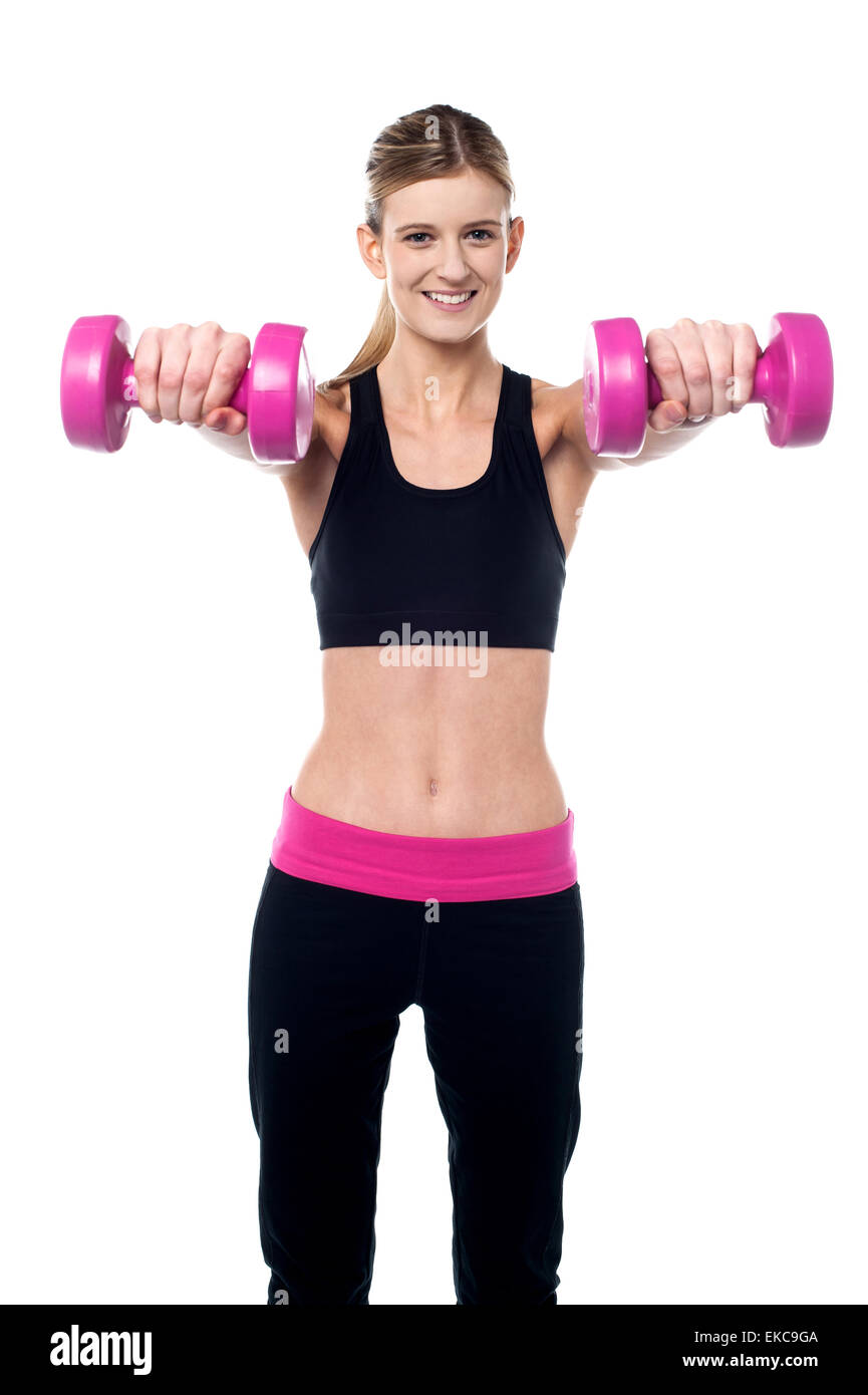 Trainer holding dumbbells in her outstretched arms Stock Photo