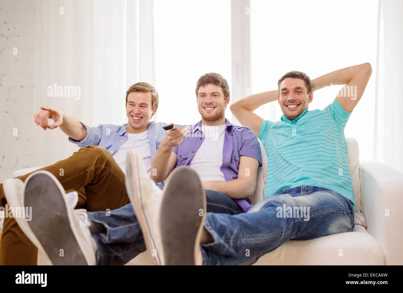 smiling friends with remote control at home Stock Photo - Alamy
