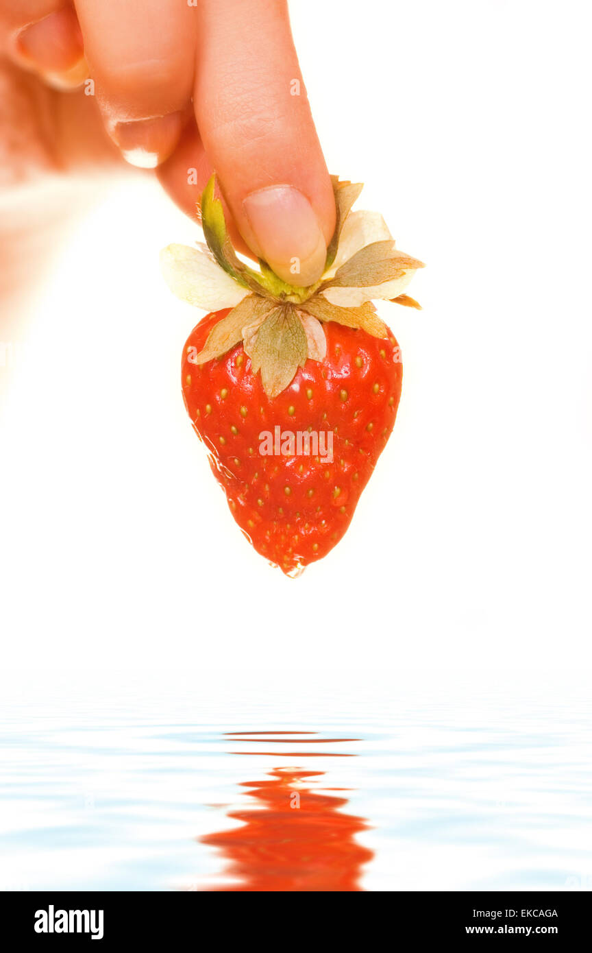 Woman's hand with a fresh juicy strawberry Stock Photo - Alamy