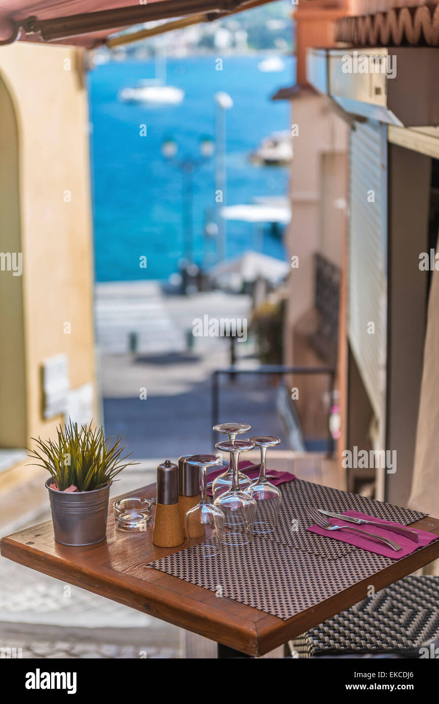 A bistro table outside a brasserie with a view of the harbour in the distance Stock Photo