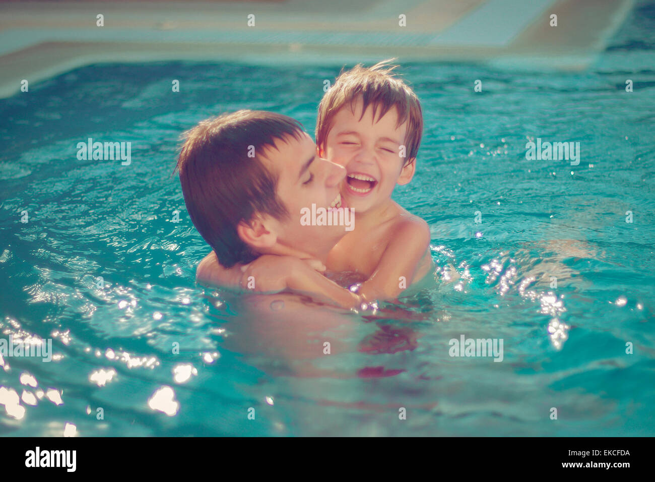 Two brothers playing in a swimming pool Stock Photo - Alamy