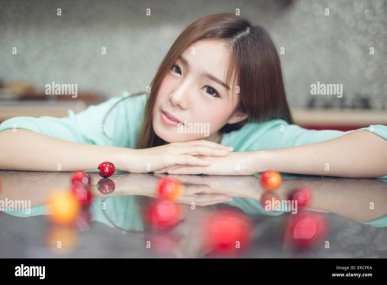 Young women in kitchen with cherries Stock Photo