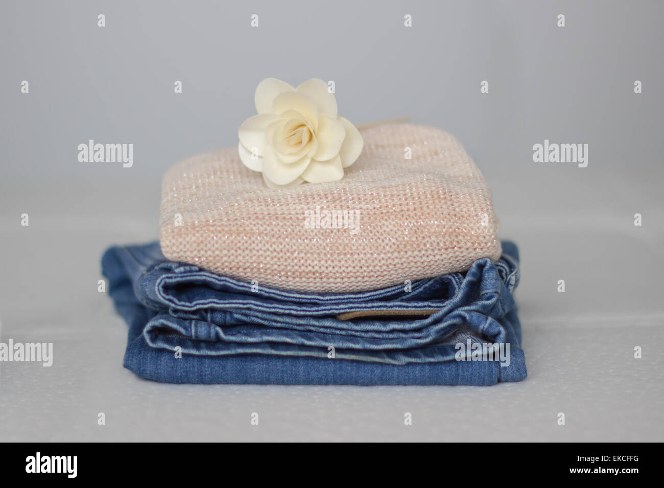 A pile of clothes with a flower on top Stock Photo