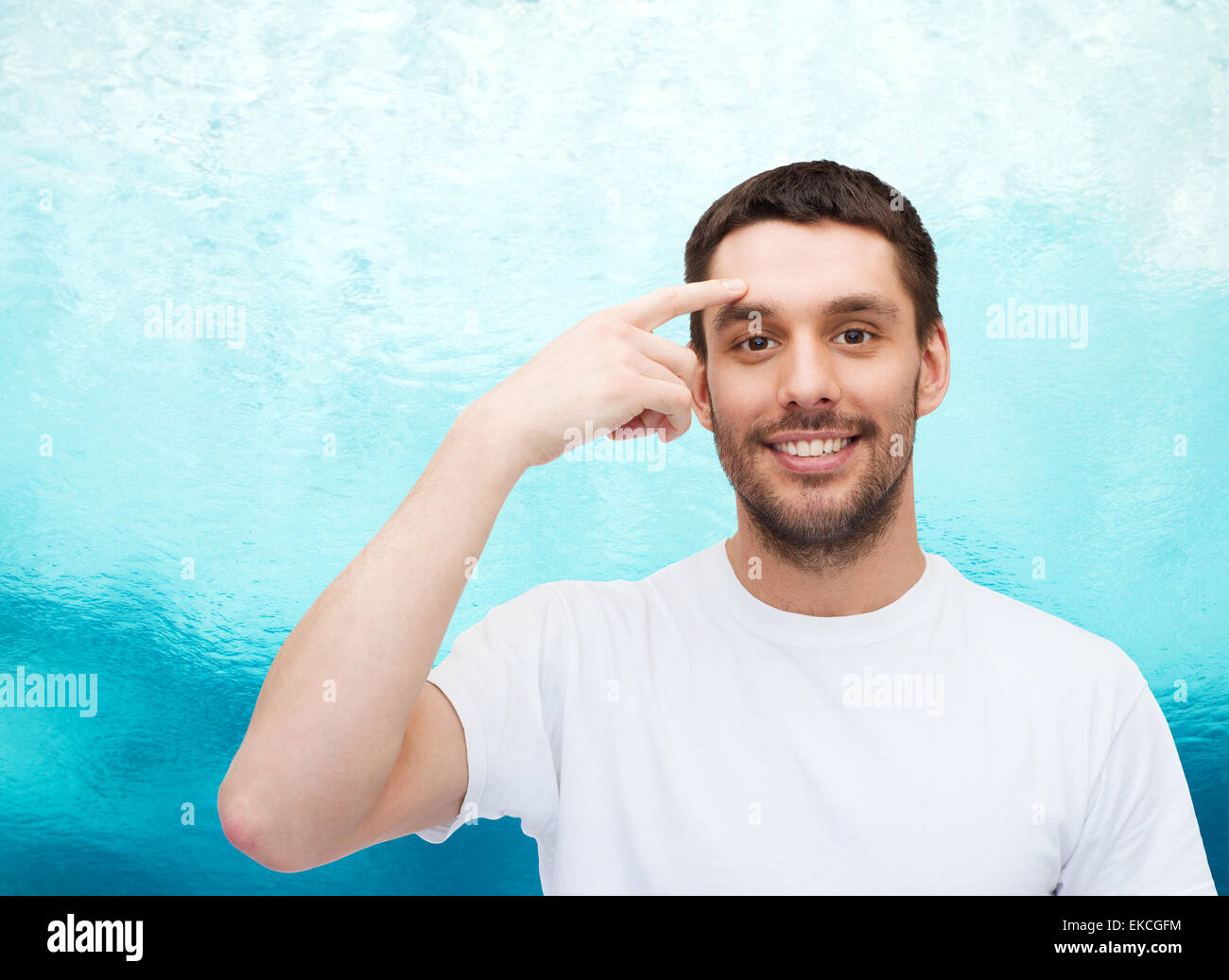 smiling young handsome man pointing to forehead Stock Photo
