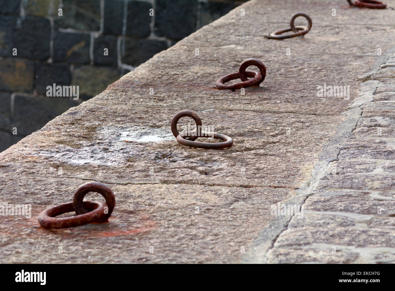 Mooring rings for boats to tie to securely on Mullion harbour wall, Cornwall, England Stock Photo