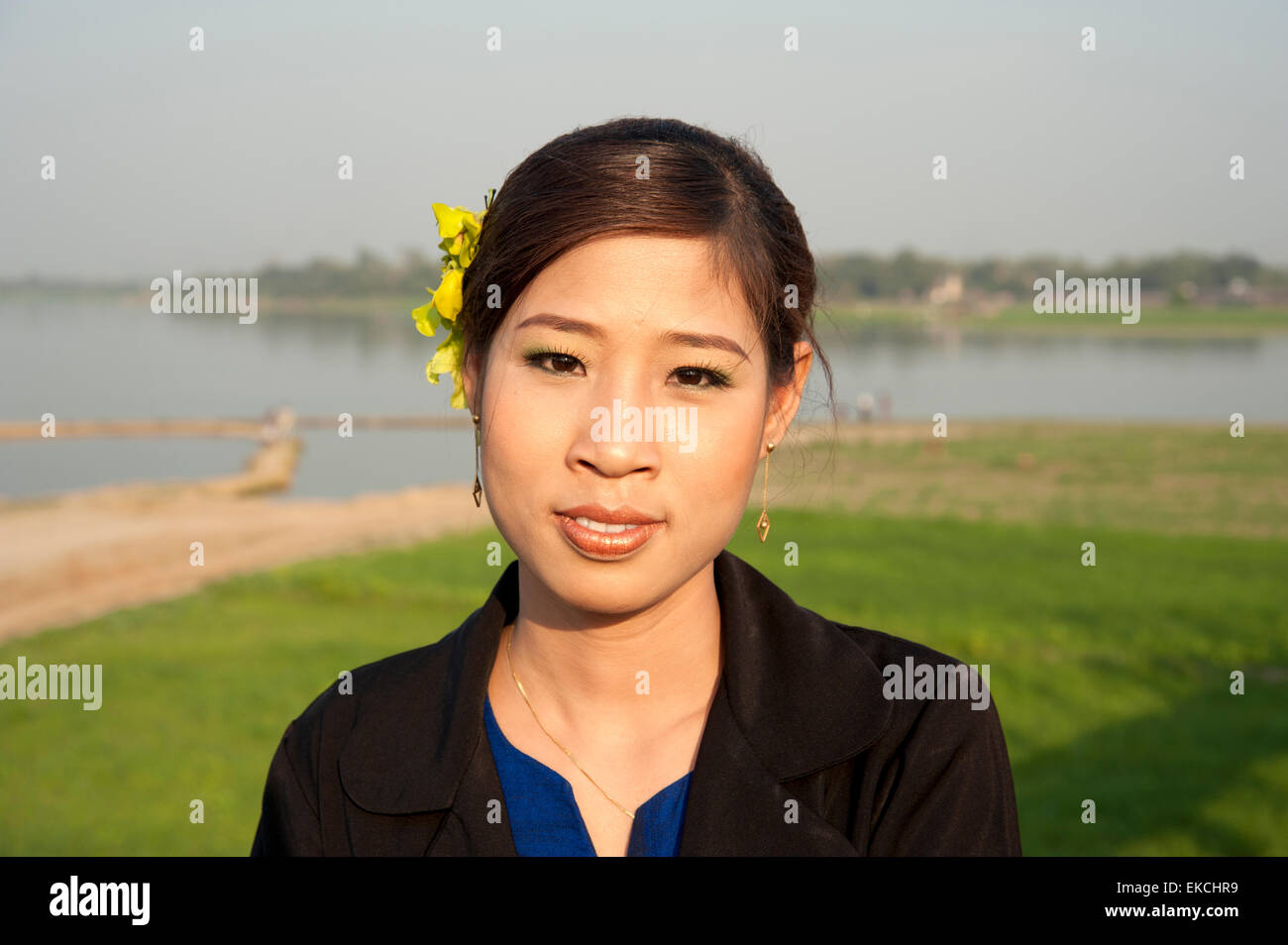 A pretty Burmese girl smiles for a portrait on the U Bein bridge on