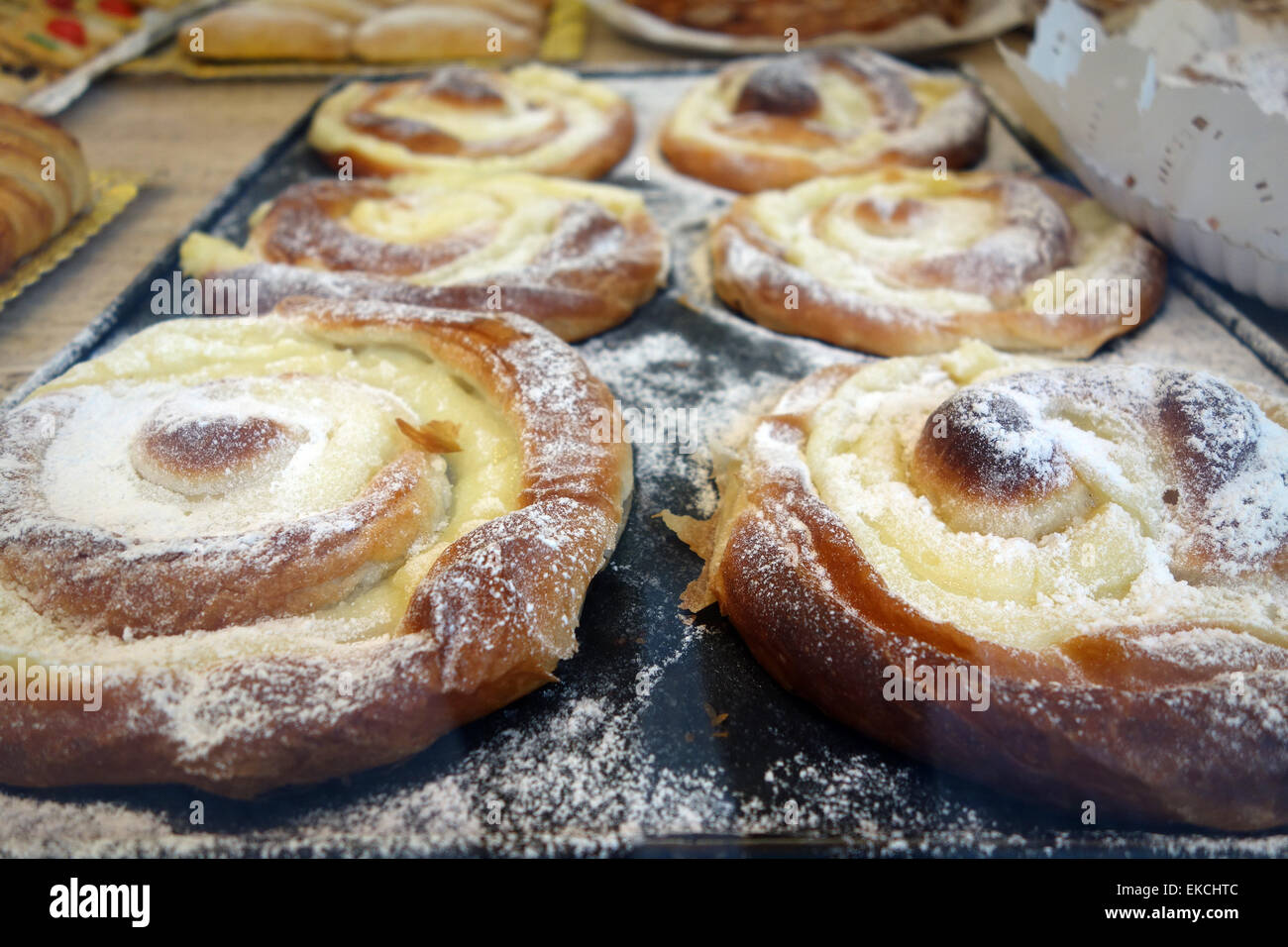 Creme filled ensaïmadas (sweet pastry from Mallorca) on tray in Stock ...