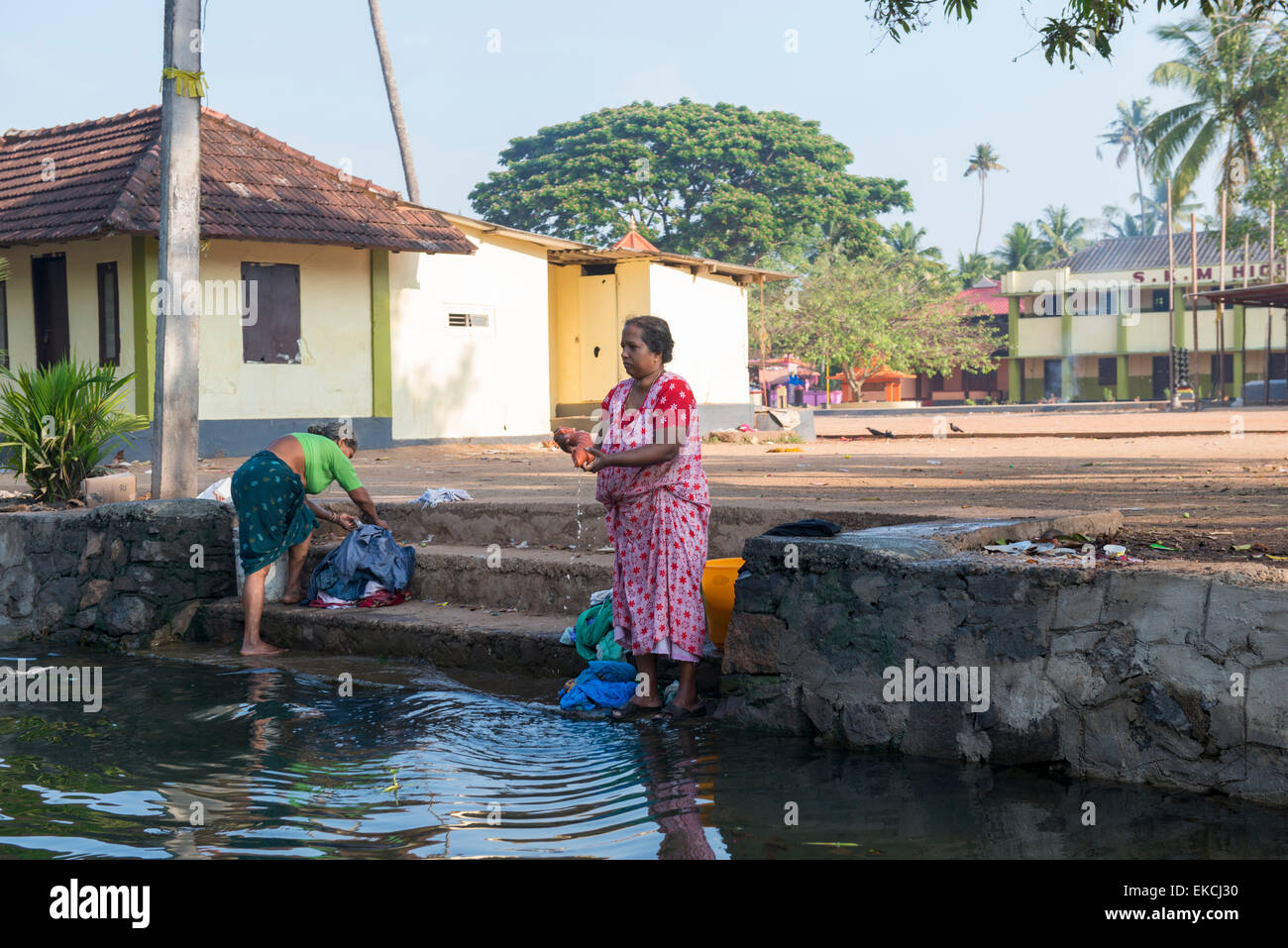 Women washing their laundry in the Backwaters of Kumarakom, Kerala India Stock Photo