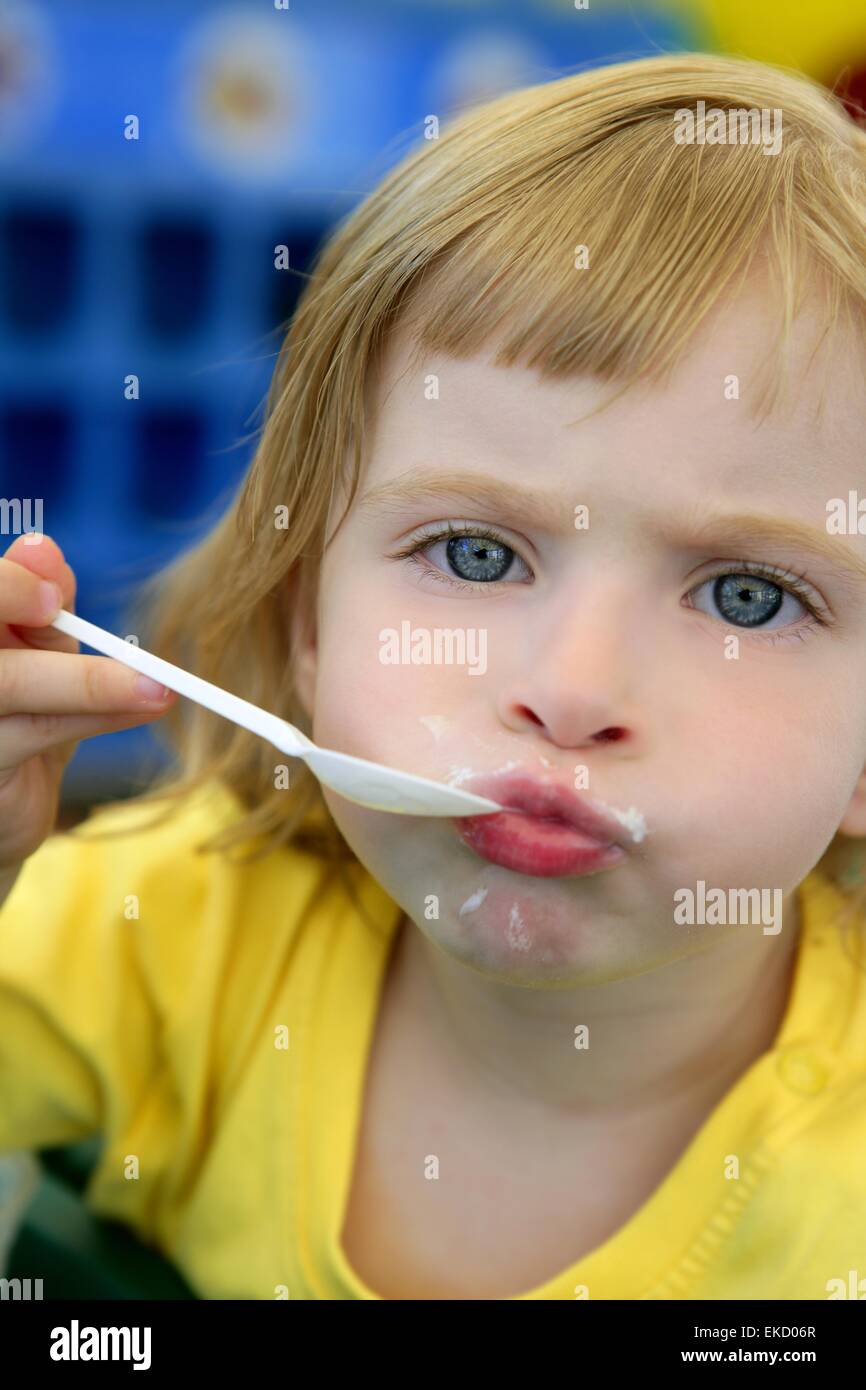 Blond little girl eating and gesturing Stock Photo Alamy