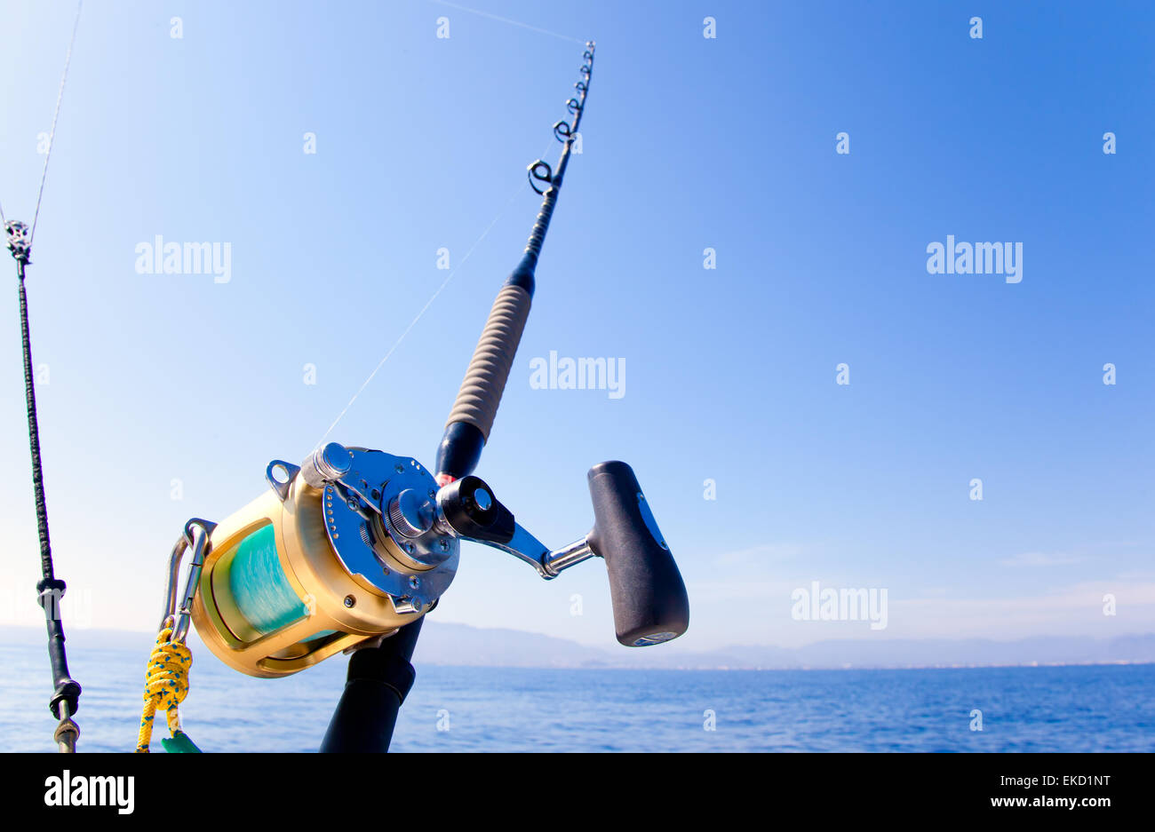 fishing boat trolling in ocean with golden reel Stock Photo - Alamy