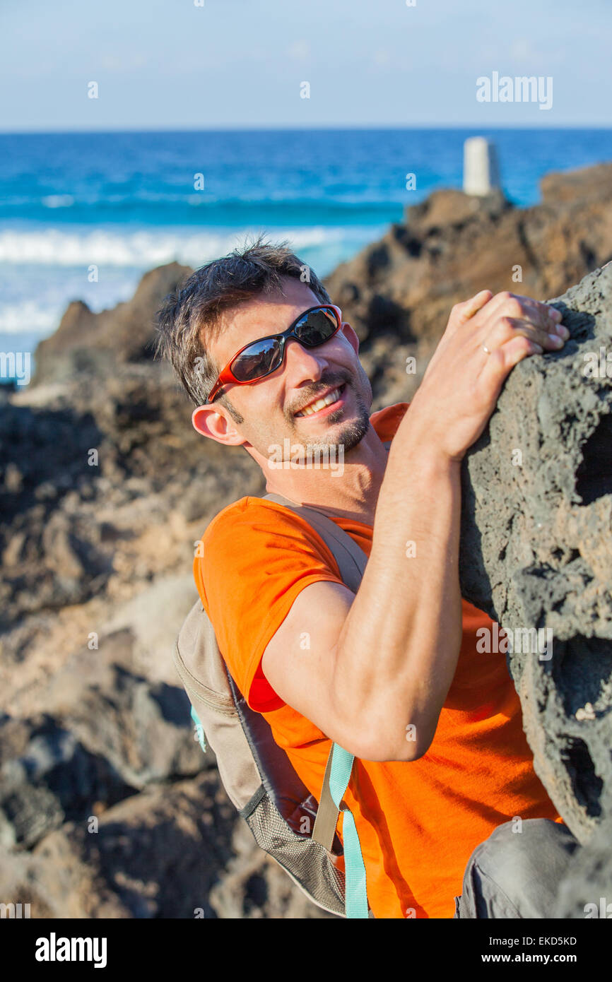 Young man in glasses with backpack climbing Stock Photo Alamy