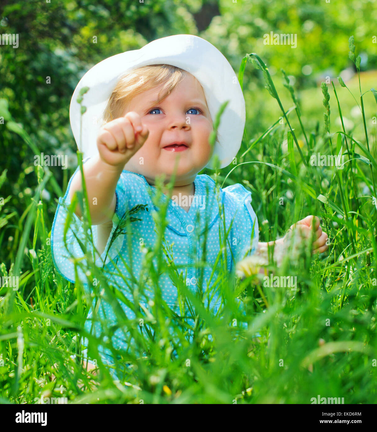 little girl sitting in the grass in the park Stock Photo - Alamy