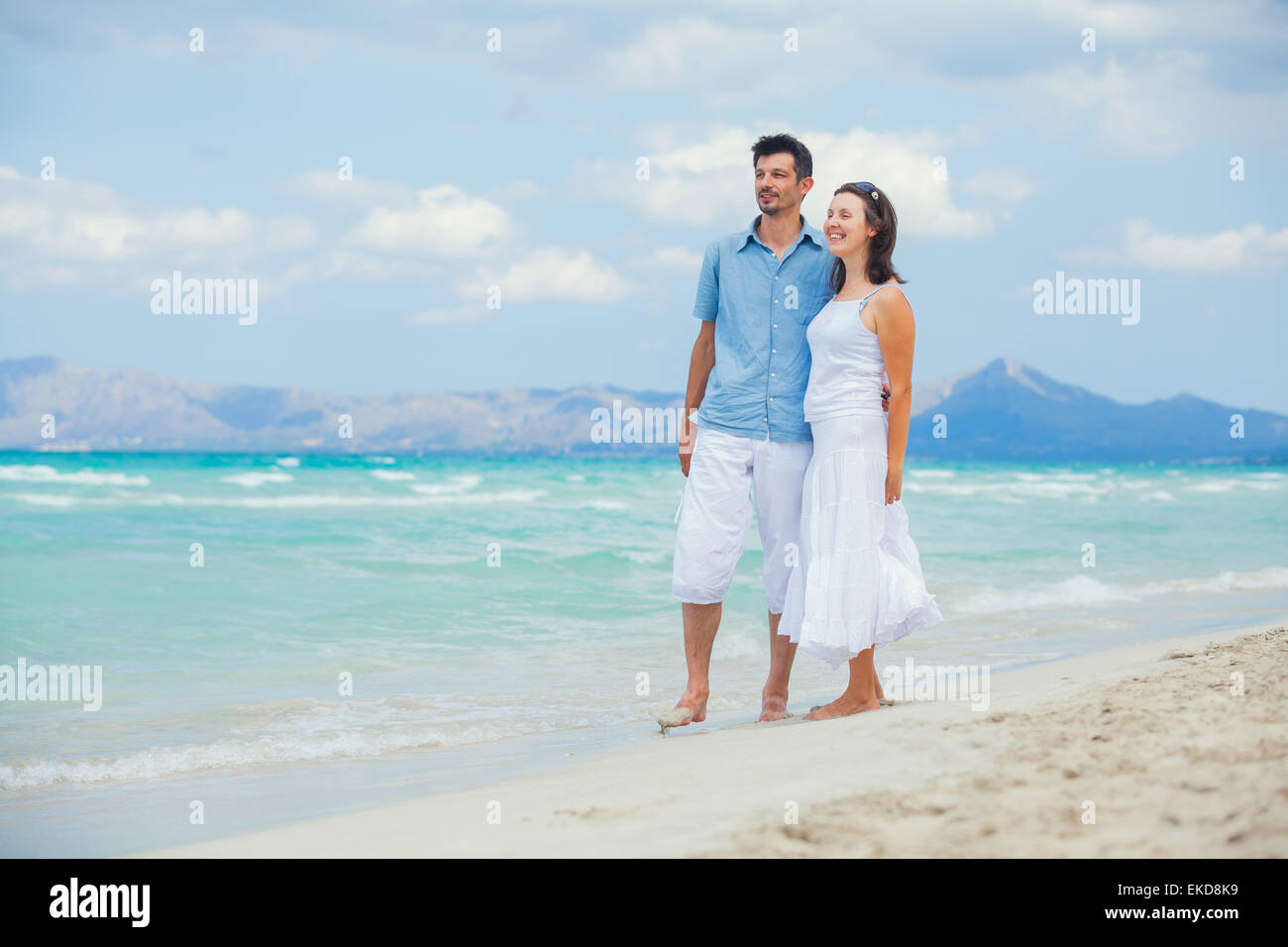 Happy young couple walking on a tropical beach Stock Photo - Alamy
