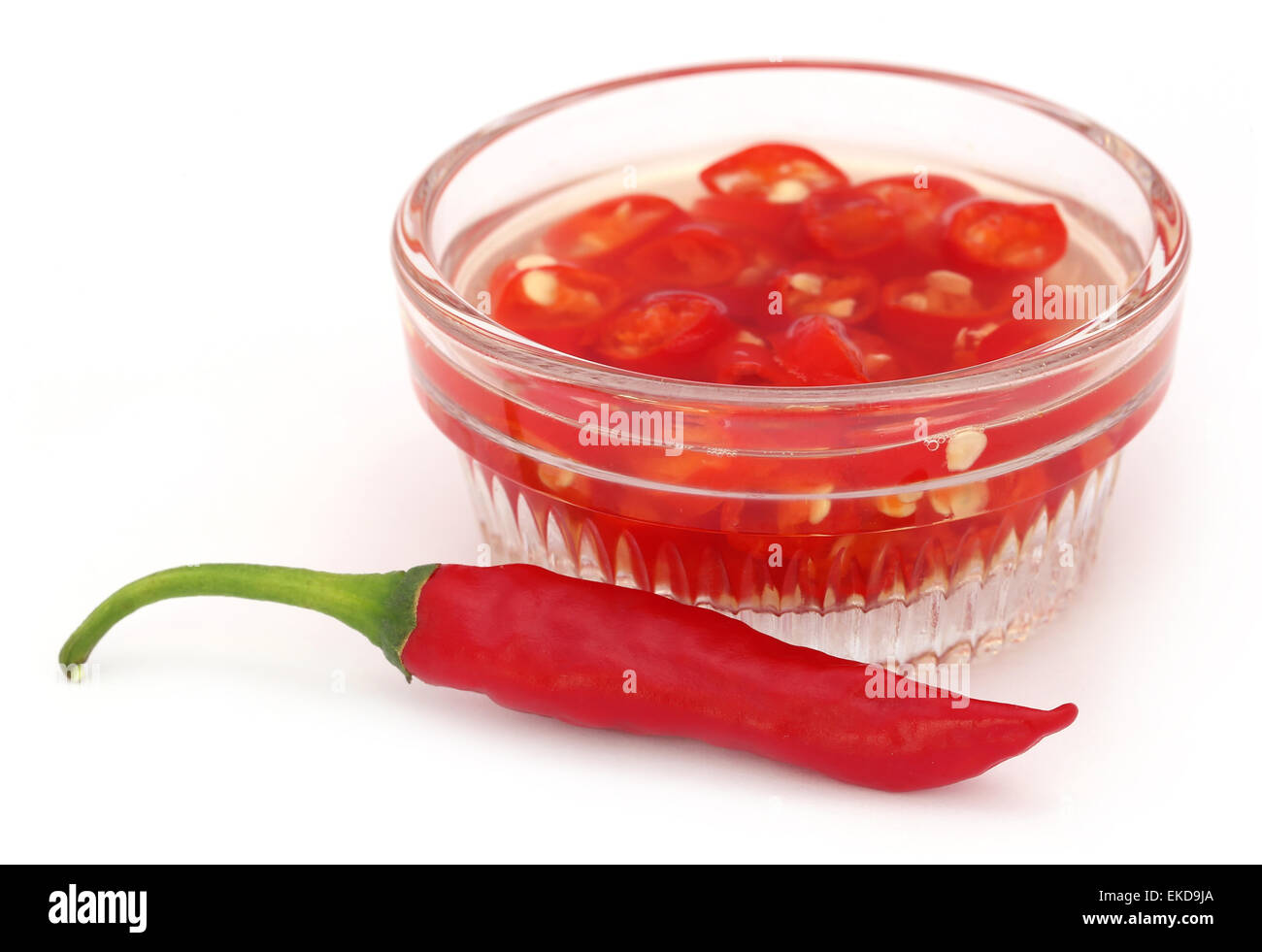 Red chili peppers in a transparent bowl over white background Stock Photo